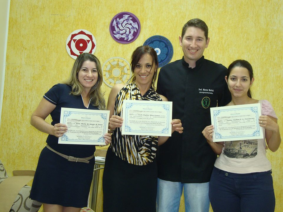 Marcos Martini com alunas exibindo certificados de formação